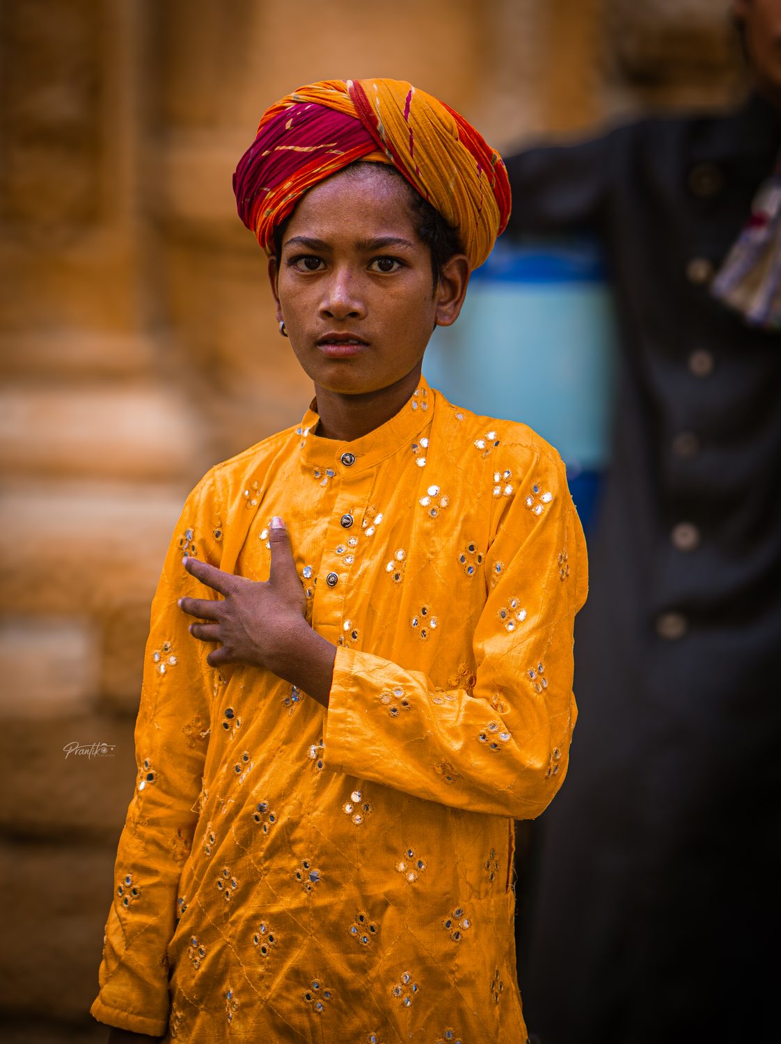 A young boy in a saffron turban and kurta