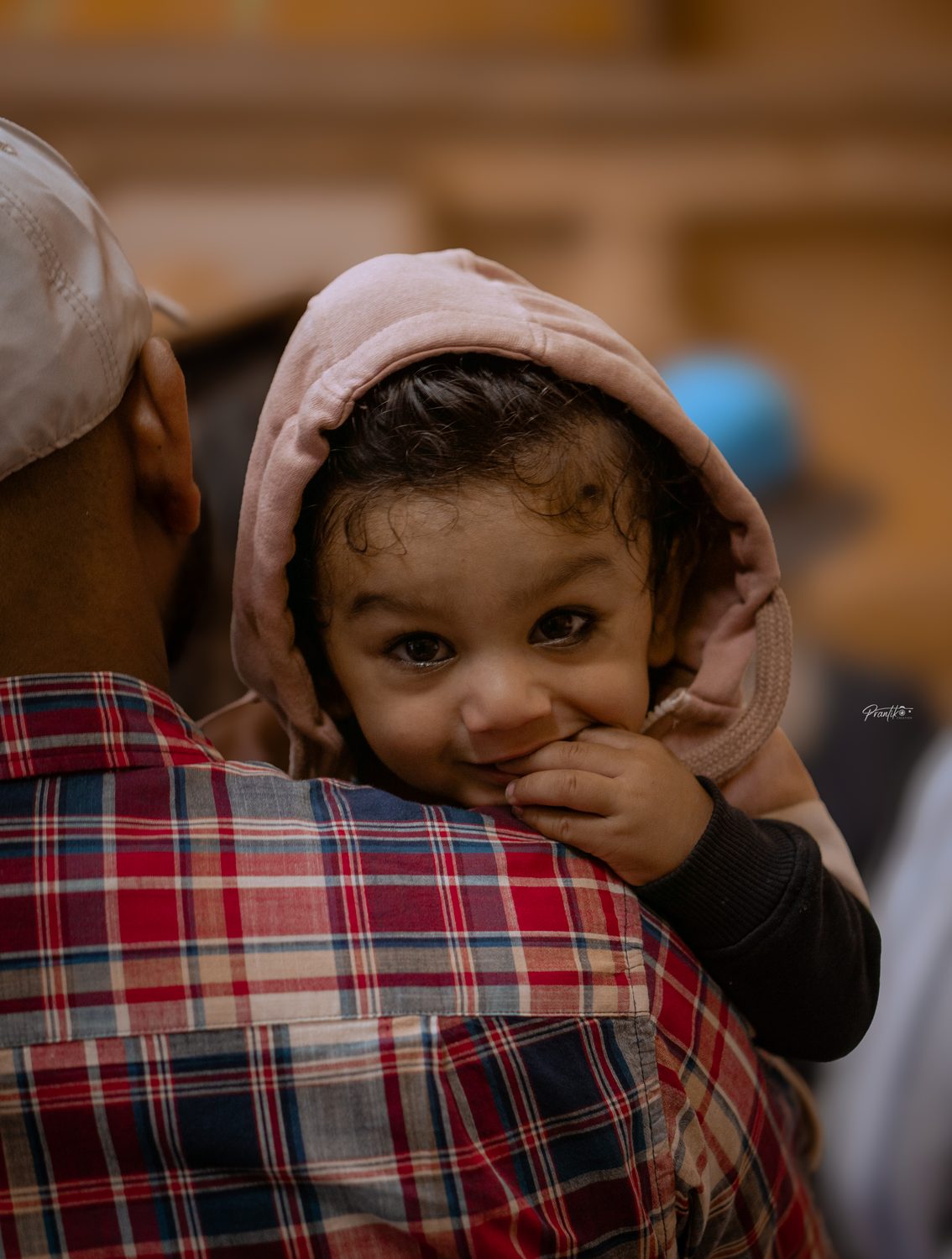 A smiling child looking over a shoulder