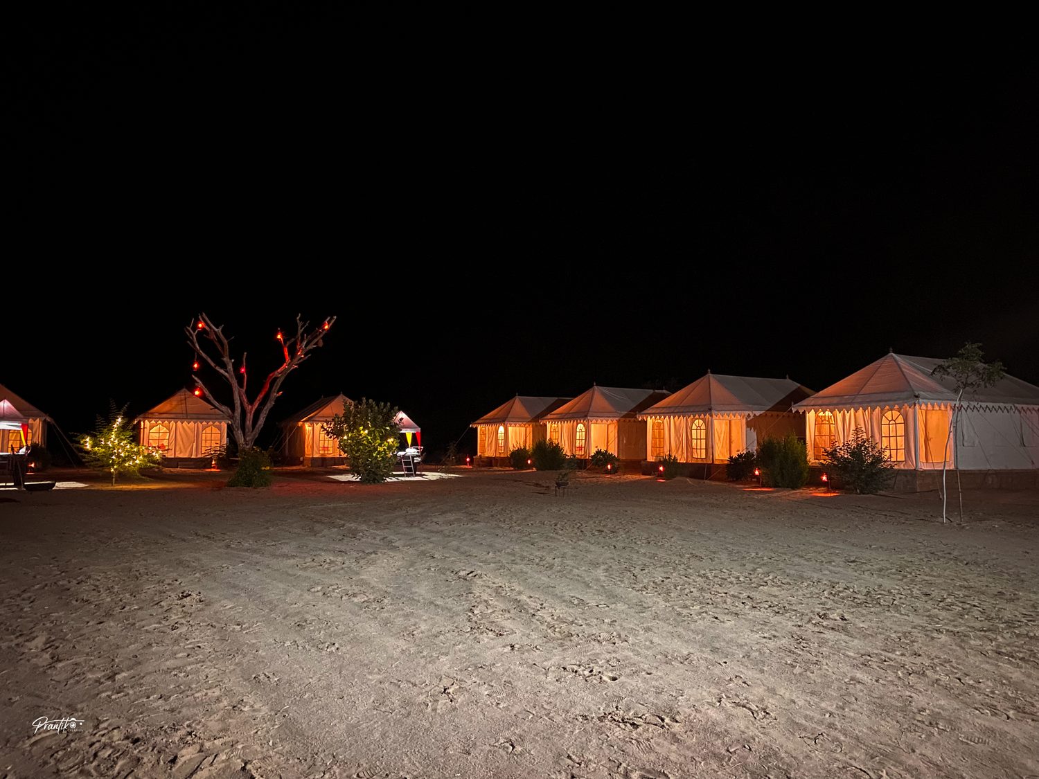 Glowing tents at a desert camp at night