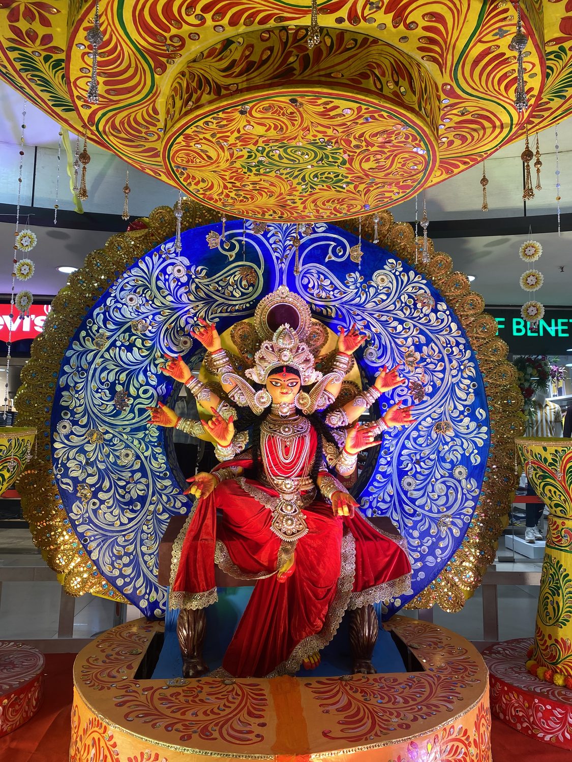 A red and gold Durga idol in an ornate pandal
