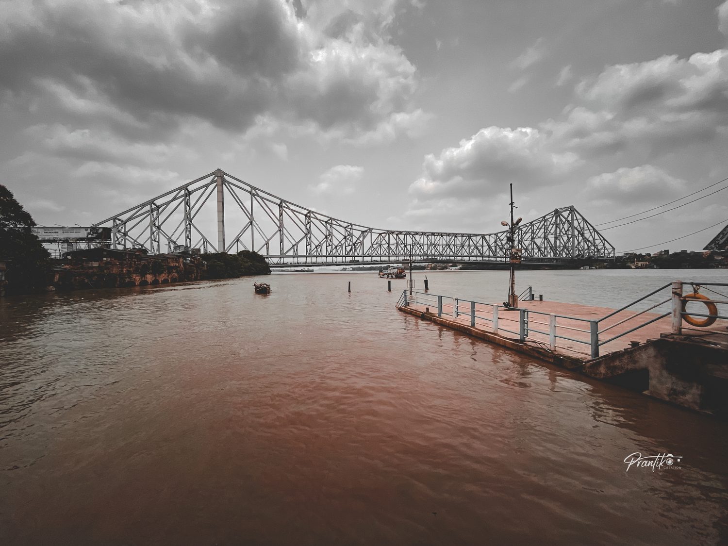 Howrah Bridge over the Hooghly under a monsoon sky