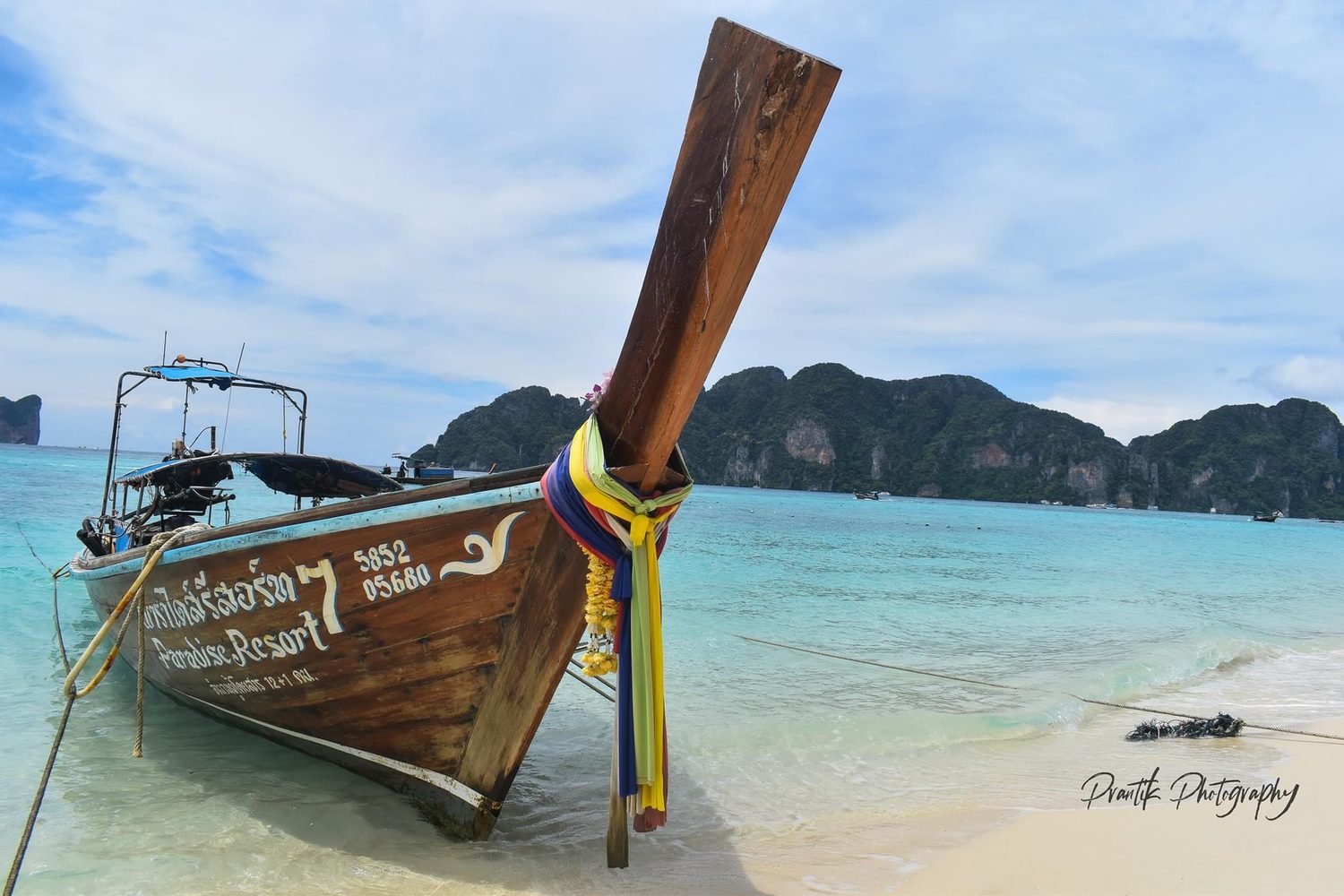 A longtail boat on a turquoise beach in Thailand